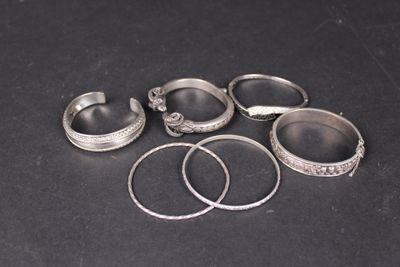 six anneaux en argent et deux anneaux en argent sur un fond noir