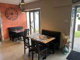 une salle à manger avec une table, des chaises et une horloge accrochée au mur