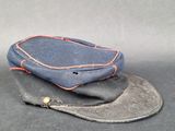 un chapeau bleu orné d'une couture rouge