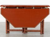 a small table with a red top and a wooden base