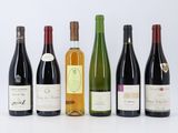 six bouteilles de vin sont alignées sur une surface blanche