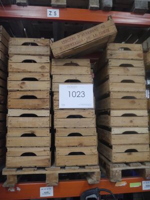 de nombreuses caisses en bois empilées sur une étagère dans un magasin
