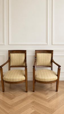 deux chaises en bois posées sur un parquet, près d'un mur blanc