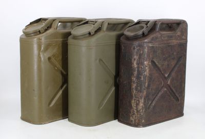 three metal cans are lined up in a row on a white surface