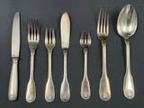 five forks and five spoons on a black table
