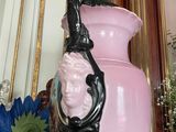 a pink vase with a face on it sitting on a table