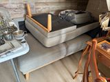 un canapé sur lequel se trouve un plateau et une table sur laquelle est posé un sac
