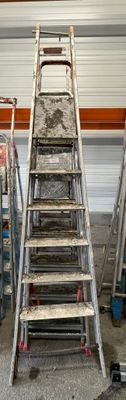 de nombreuses échelles entreposées dans un garage