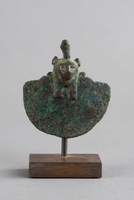 une image représentant une statue en bronze d'un homme assis sur un rocher