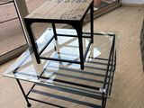 une table en verre surmontée d'un piètement en métal