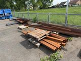 a pile of wood sitting in a parking lot next to a fence