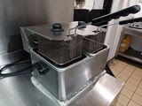 two deep fryers sitting on a counter in a kitchen