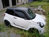 a small white car parked in front of a building