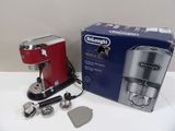 a red coffee maker sitting on a table next to a box of coffee