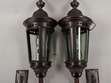 pair of antique style outdoor wall lights mounted on a white wall