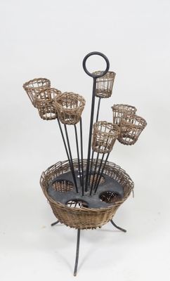 a basket with a bunch of flowers in it on a stand