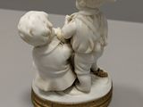 a figurine of a boy and a girl holding hands