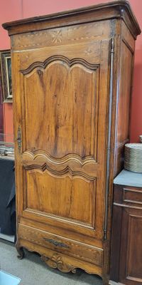 une armoire en bois dans une pièce où se trouve un miroir accroché au mur