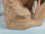 a clay sculpture of a bear that is sitting on a table