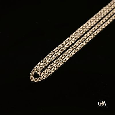 une chaîne en argent posée sur une surface noire