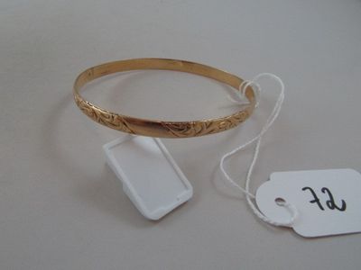 a gold bracelet with a tag attached to it