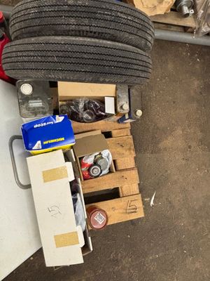 un tas d'objets divers posés par terre à côté d'un tas de pneus