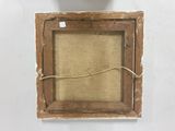 an old picture frame hanging on a wall next to a vase