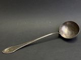 silver spoon on a black surface with a small spoon in the middle