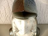 une figurine en céramique représentant une femme portant un casque, posée sur une table