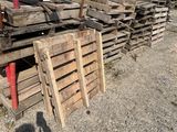 a pile of wooden pallets on the ground next to a building