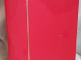 a close up of a red book on a white cloth