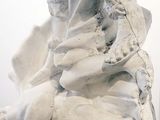 a statue of a woman sitting on top of a rock