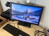 un bureau sur lequel se trouvent un écran, un clavier, une souris et d'autres éléments