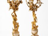 paire de candélabres dorés ornés de personnages et de fleurs, sur des socles en marbre