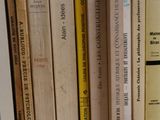 several books are lined up in a row on a white surface