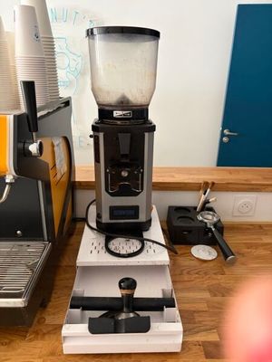 un mixeur posé sur un plan de travail, à côté d'une machine à café