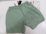 a pair of green shorts and a white shirt on a bed