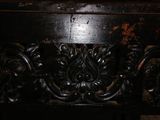 a close up of a wooden bench with carvings on it