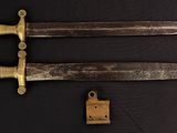 an image of a pair of old swords on a black background
