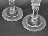 two clear glass candlesticks sitting on a black table