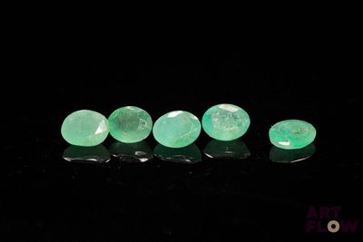 a close up of a group of green stones on a black surface