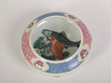 a small bowl with a fish in it on a table