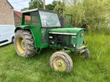 un tracteur vert garé dans l'herbe