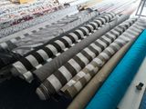 many rolls of fabric on a table in a room