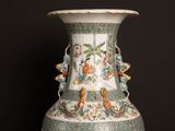 a vase with a painting on it sitting on a table