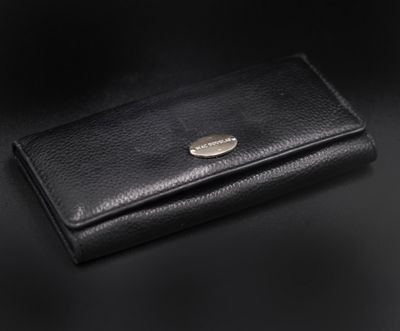un portefeuille en cuir noir posé sur une surface noire