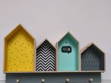 a shelf that has three different colored houses on it