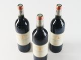three bottles of wine sitting on top of a white surface