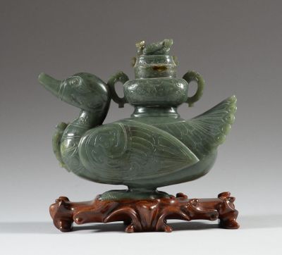 une image représentant un vase vert posé sur un socle en bois