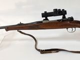 un vieux fusil muni d'une lunette de visée et d'un porte-lunette, sur fond blanc